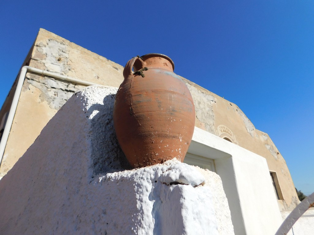 Terracotta amphora on a whitewashed wall — classic Santorini detail